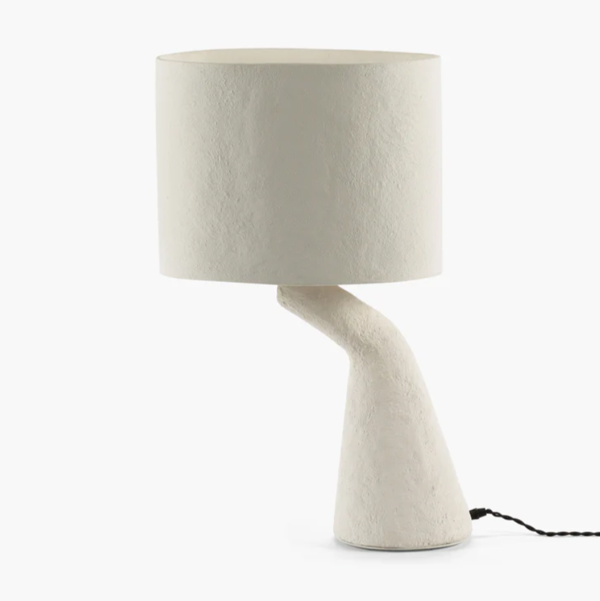 The Earth Table Lamp by Marie Michielssen is a modern designer table lamp with generous dimensions and a striking base in the shape of an arm, creating a surreal effect. This modern designer table lamp comes with a classic black fabric cord and a convenient hand switch.